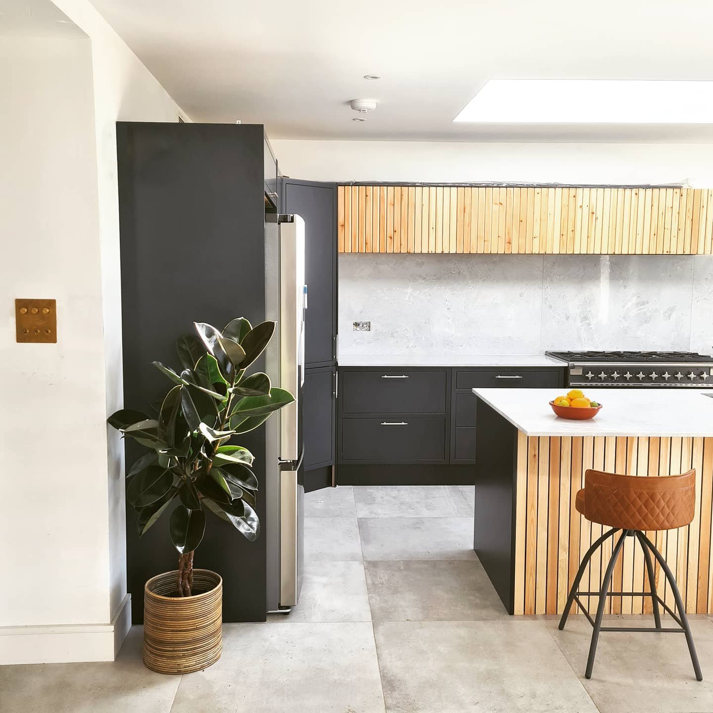 Modern kitchen with wood slat details by SGS Carpentry