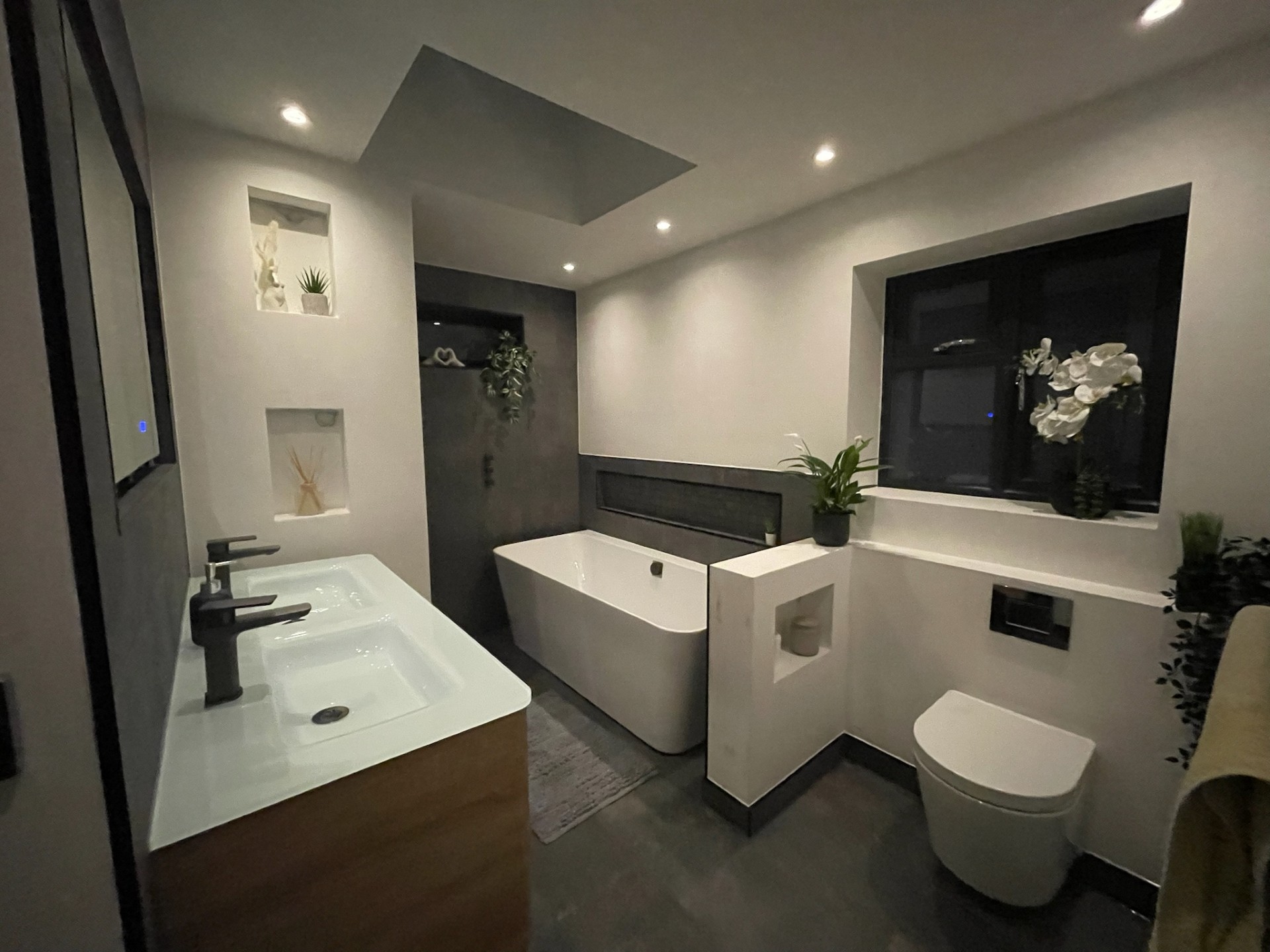 Full bathroom suite with freestanding bath and wall-hung toilet