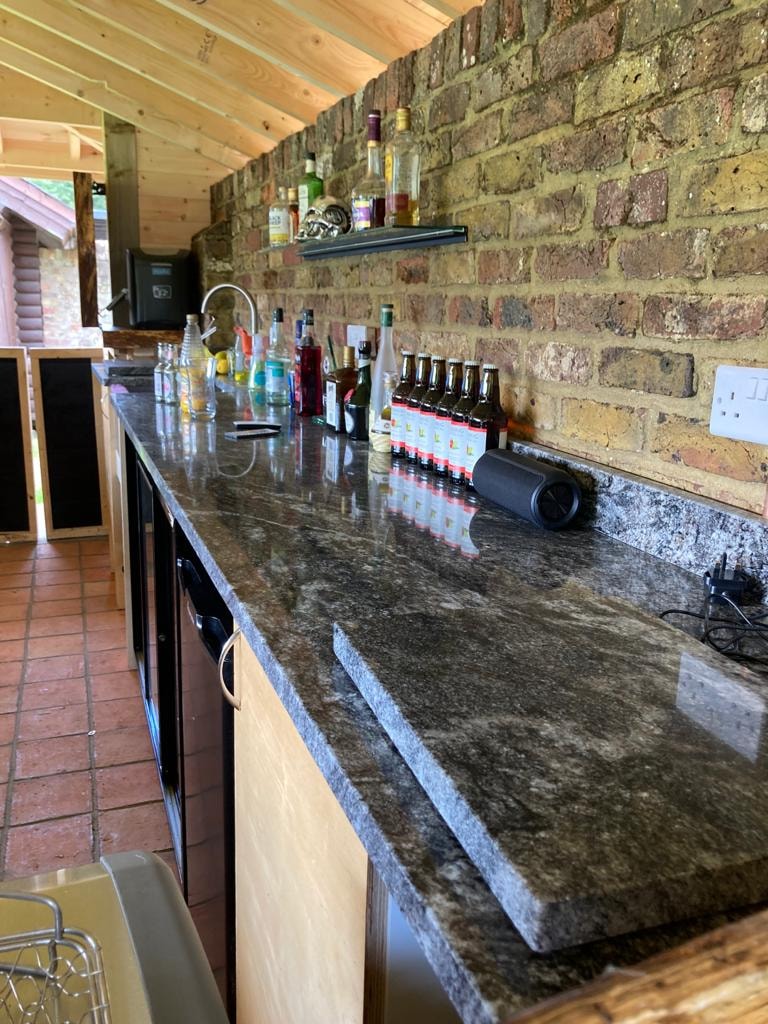 Outdoor bar interior with granite top and exposed brick wall