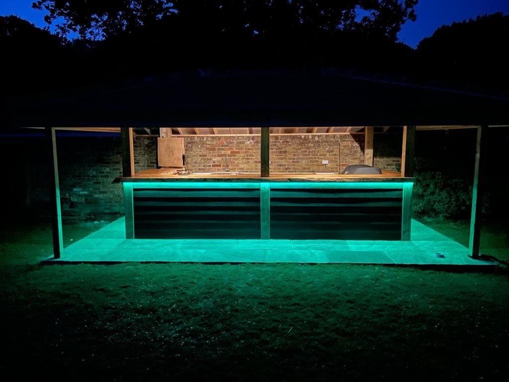 Outdoor bar gazebo lit at night with LED strip lighting