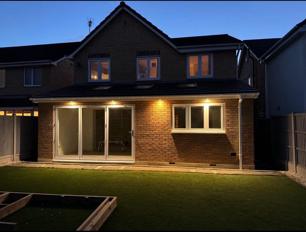 Completed house extension at night with bifold doors lit up