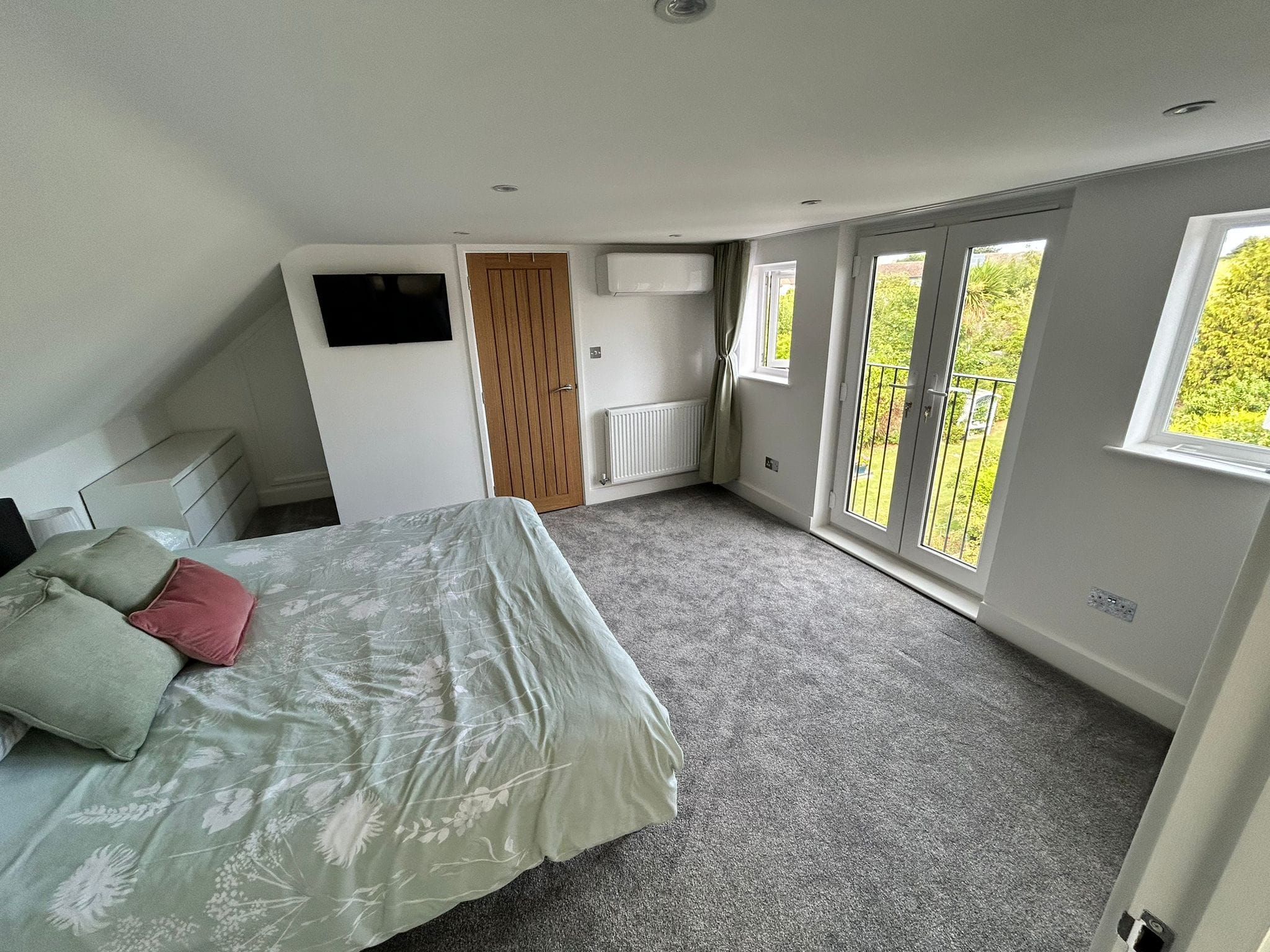 Completed loft conversion bedroom interior with Juliet balcony doors